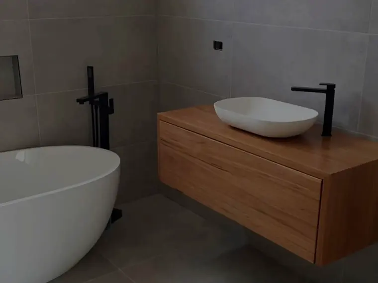 Freestanding bath with floor-mounted mixer and timber vanity