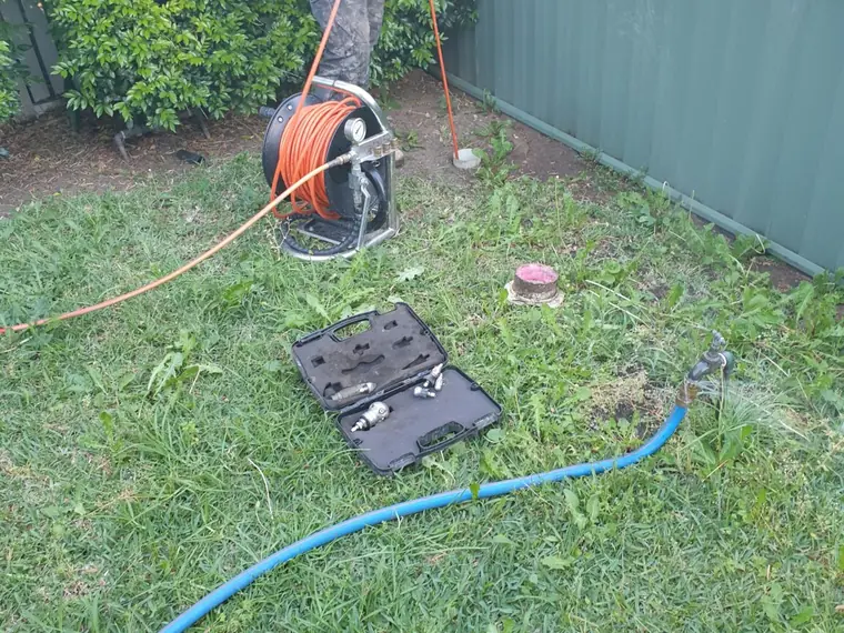 Drain clearing machine set up beside a residential boundary trap