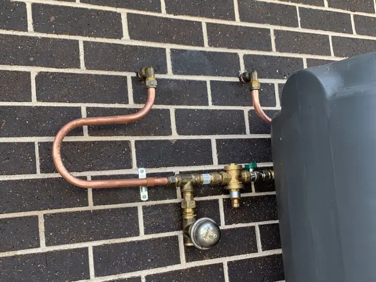 Copper gas service upgrade with regulator installed on a brick wall